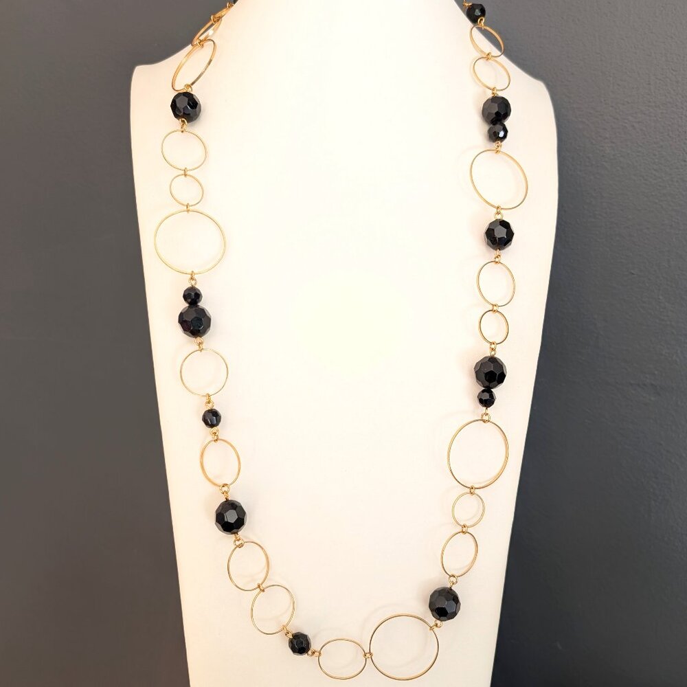 Single strand gold tone circle necklace with black faceted beads